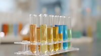Laboratory test tubes with colorful liquid samples in clear rack, scientific research setting for chemical analysis and experimentation.