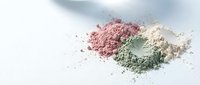 Natural cosmetic clay powder in pink green white colors for skincare beauty treatments and spa wellness routines on clean background.