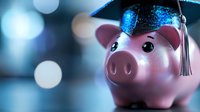Pink ceramic piggy bank wearing graduation cap with tassel against blurred blue bokeh background symbolizing education savings and financial planning for college.