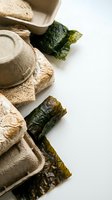 Eco-friendly biodegradable packaging materials with dried seaweed sheets on white background for sustainable food storage and zero waste lifestyle.