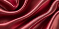 Luxurious burgundy silk fabric with elegant folds and waves creates dramatic light and shadow effect, suitable for fashion and luxury backgrounds.