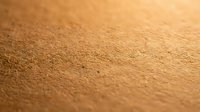 Golden sand texture with fine grains creating natural patterns in warm sunlight for backgrounds and nature designs.