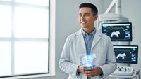 Young Hispanic male doctor in white coat smiling while holding tablet in modern medical office with ultrasound equipment and large windows.