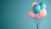 Festive bunch of pink and turquoise balloons floating against teal background, creating minimalist party decoration composition with soft pastel colors.