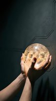 Hands holding glowing sphere with circuit board pattern against dark tech background, representing artificial intelligence, innovation, and digital transformation for technology concepts.