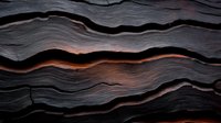Dramatic layered rock formation with glowing orange light between dark stone strata creates abstract natural pattern. Geological background for design projects.