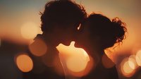 Romantic couple silhouette kissing at sunset with warm bokeh lights creating intimate atmosphere for love and relationship concepts.