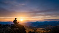 Man meditating on mountain peak during golden sunrise with dramatic sky and layered mountain ranges creating peaceful spiritual atmosphere.