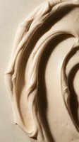Cream-colored cosmetic product with rich, swirled texture and dimensional waves creating luxurious appeal for skincare, beauty, and wellness marketing materials.