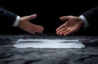 Business people reaching for handshake over blank contract paper on dark table, dramatic lighting emphasizes negotiation and agreement moment in corporate setting.