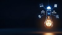 Glowing light bulb with floating technology icons representing innovation, creativity and digital transformation concepts for business presentations.