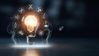 Glowing light bulb with innovation icons floating around representing creative ideas, technology solutions, and business inspiration on dark background.