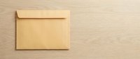 Brown kraft paper envelope on wooden background with copy space for business correspondence and mailing needs.