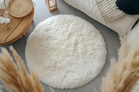 Cozy round white faux fur rug on gray floor with decorative elements, pampas grass and wooden tray creating minimalist scandinavian home interior atmosphere.