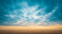 Dramatic turquoise and golden sky with dynamic cloud formations stretching over endless horizon at sunset, creating atmospheric moody landscape for nature backgrounds.