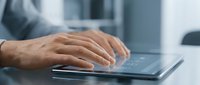 Professional businessman hands typing on modern laptop keyboard in contemporary office environment for business productivity and workflow solutions.