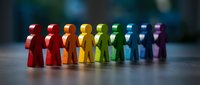 Colorful wooden figures standing in rainbow formation representing diversity, teamwork and inclusion concepts for business presentations and social campaigns.