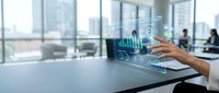 Businessman analyzing financial data on holographic display in modern office with city skyline view, suitable for business technology and analytics concepts.