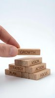 Hand placing wooden block labeled Growth on pyramid of business concept blocks with Strategy, Plan, Action, Focus, Vision words on white background.