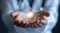 Glowing sparkler light in cupped hands of business person against dark background, symbolizing innovation, opportunity, and creative potential.