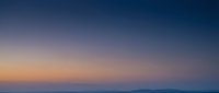 Serene twilight sky with gradient colors transitioning from warm orange to deep blue, creating peaceful atmospheric background for meditation and wellness content.