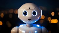Friendly white robot with glowing blue eyes and gentle expression against dark background with bokeh lights, showcasing modern artificial intelligence technology.