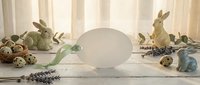Easter composition with ceramic bunnies, quail eggs, lavender sprigs and blank card on white wooden background for spring holiday greeting design.