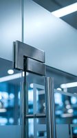 Modern glass door with stainless steel hinges in contemporary office building interior showcasing sleek architectural design and professional workspace elements.