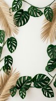 Tropical frame with green monstera leaves and golden palm fronds on neutral background creating natural border for summer design projects.