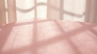 Soft pink textured surface with geometric window shadow patterns creating warm natural lighting effects for interior design backgrounds.