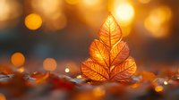 Glowing autumn leaves arranged in Christmas tree shape against blurred golden bokeh background, creating magical seasonal atmosphere for festive designs.