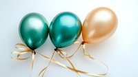Metallic green and gold balloons with elegant gold ribbons on white background, festive party decoration isolated for celebration designs and holiday layouts.