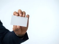 Businessman holding blank white business card in hand against isolated background for corporate branding and contact information display.