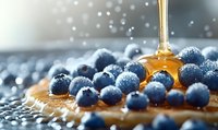 Golden honey drizzling over fresh blueberries in macro shot, creating appetizing breakfast scene with morning light and water droplets in background.