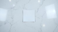Blank white square card mockup on elegant marble surface with soft lighting for branding and design presentations.