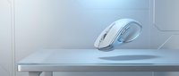 Modern wireless computer mouse floating above white desk surface in minimalist office workspace with clean geometric background for technology concepts.