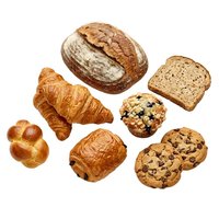 Assorted fresh baked goods including croissant, artisan bread, whole wheat toast, muffin and chocolate chip cookies isolated on white background for bakery, cafe and food design projects.