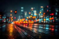 Blurred city street at night with colorful bokeh lights reflecting on wet pavement creating atmospheric urban scene for backgrounds and mood concepts.