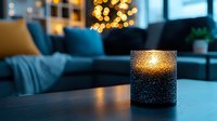 Glowing candle holder with water droplets creates cozy atmosphere in modern living room with blue sofa and bokeh lights from Christmas tree in background.