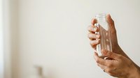 Person holding empty glass jar, studio shot with neutral background, suitable for recycling, sustainability, storage, and eco-friendly concepts.