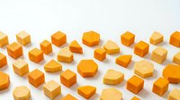 Orange and yellow geometric wooden blocks scattered on white background. Various shapes including cubes, cylinders, triangles in warm tones for design projects.