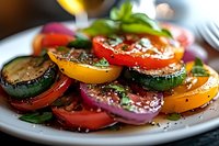 Fresh colorful vegetable salad with sliced tomatoes, zucchini, red onions and herbs seasoned with black pepper and spices on white plate, macro food photography.