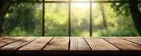 Empty rustic wooden table surface against blurred green garden background with sunlight, suitable for product display or montage presentation.