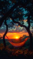 Tranquil hammock silhouetted against vibrant orange sunset sky, framed by curved tree branches creating natural arch. Perfect for travel, relaxation and outdoor lifestyle advertising.