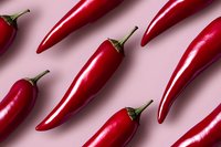 Fresh red chili peppers arranged in diagonal rows on pink background, creating minimalist geometric pattern for food and culinary projects.