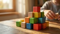 Colorful wooden building blocks arranged in pyramid formation on table with child playing in background, educational toy for creative development.