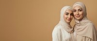 Two young Middle Eastern women wearing beige hijabs embracing warmly against neutral background, showcasing sisterhood and cultural diversity for lifestyle content.