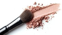 Makeup brush with crushed rose gold shimmer powder creating artistic sweep mark on white background, professional cosmetics application tool for beauty industry.