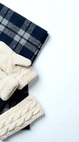Cozy winter fashion flat lay with navy plaid scarf, cream knit mittens and cable knit hat on white background for seasonal styling and warmth.