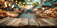 Rustic wooden table with blurred night market background, festive string lights and food stalls creating atmospheric bokeh effect.